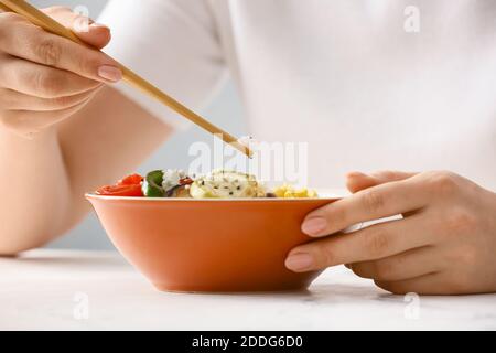 Donna che mangia insalata di riso con verdure Foto Stock