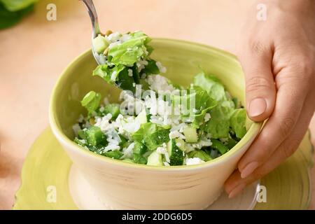 Donna che mescola insalata di riso con verdure sul guardaroba della tavola Foto Stock