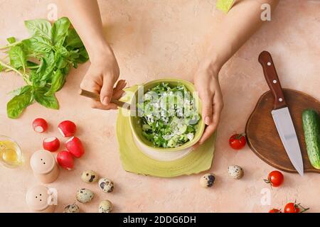 Donna che mescola insalata di riso con verdure sul tavolo Foto Stock