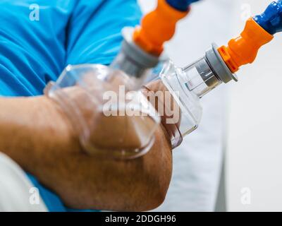 Paziente di sesso maschile non riconoscibile con ventose a vuoto sul braccio appoggiate panca durante la seduta di fisioterapia in ospedale Foto Stock