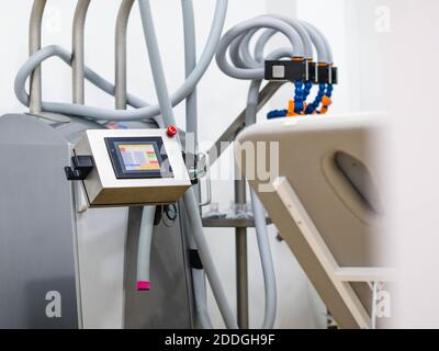 Moderna macchina da vuoto con schermo colorato situata vicino alla panca all'interno studio di fisioterapia in ospedale Foto Stock