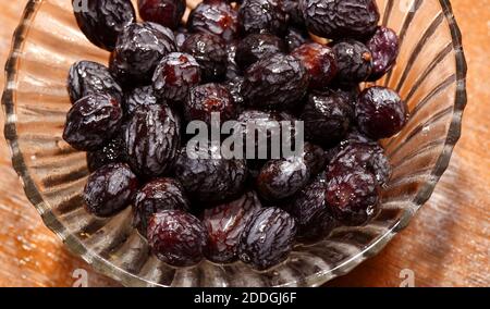 Il raisin nero imbevuto noto per il suo gusto zuccherino e il sapore succoso, l'uva passa nera, il Kishmish (uva secca) sono prodotti asciugando le uve senza semi di Corinto. Foto Stock