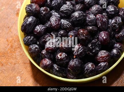 Il raisin nero imbevuto noto per il suo gusto zuccherino e il sapore succoso, l'uva passa nera, il Kishmish (uva secca) sono prodotti asciugando le uve senza semi di Corinto. Foto Stock