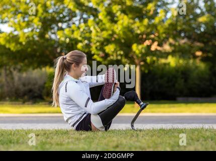 Happy African American femmina in auricolari che hanno videochiamata sul portatile mentre si siede al tavolo con una tazza di caffè nella caffetteria all'aperto Foto Stock