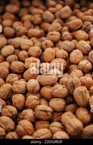 Closeup di pile sparse di noci marroni naturali non pelate per cibo e cucina concetto di fondo Foto Stock