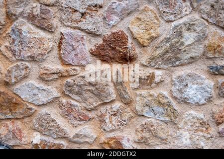 Muro di pietra sfondo e struttura, pietre rosa rosso tradizionale costruzione facciata o pavimento pavimentazione Foto Stock