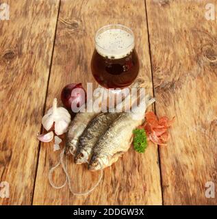 Un primo piano di un bicchiere di birra con secco pesce Foto Stock