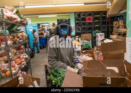 Volontari e personale aiutano a distribuire tacchino, generi alimentari e prodotti con le guardie nazionali e il governatore Cuomo al New York Common Pantry. Molte persone a causa della pandemia hanno perso il lavoro, il reddito e sono scivolati indietro in affitto, hanno iniziato a contare su molti tentativi in tutto lo stato per ricevere generi alimentari gratuiti e prodotti. Questa è la tradizione americana di avere la turchia per la cena il giorno del Ringraziamento e il governatore Cuomo ha aiutato ad organizzare la distribuzione di tacchini di Butterball e di Shady Brook Farms. Il governatore così come i volontari e il personale del comune Pantry e i membri delle guardie nazionali indossavano speciali mas facciali Foto Stock