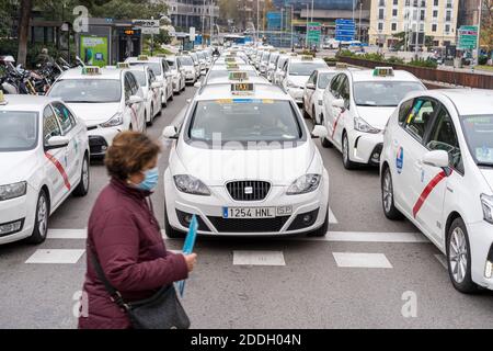 Una donna che attraversa la strada durante la dimostrazione.centinaia di tassisti dimostrano sul Paseo de la Castellana, di rivendicare i loro diritti come lavoratori autonomi mentre chiedono aiuto dal comune di Madrid, poiché il loro reddito è stato colpito a causa della pandemia del Covid 19. Foto Stock