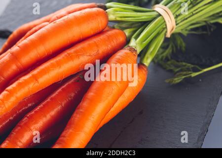 mazzo di carote fresche su sfondo scuro Foto Stock