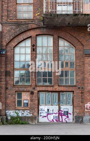 Porte e finestre di una vecchia fabbrica di ingegneria ferroviaria nel distretto di Konepaja a Helsinki, Finlandia Foto Stock