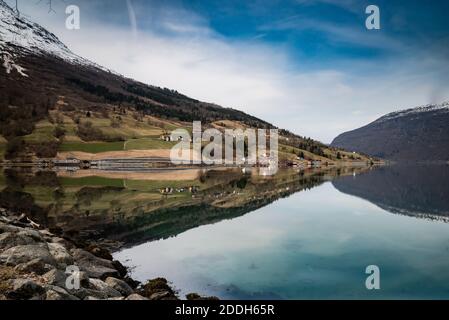 Acque calme che fanno i riflessi della montagna a Olden, Norvegia Foto Stock