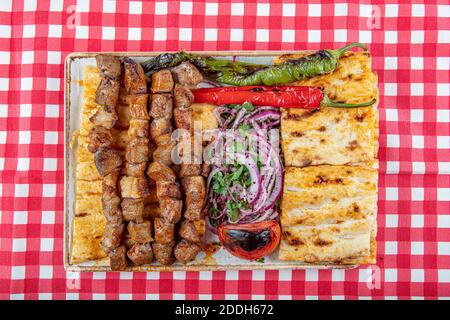 Cucina turca delizioso spiedino ciger. Spiedino di fegato, Turco Ciger Shish Kebab su piccolo barbecue con pomodori, delizioso, naturale, primo piano. Foto Stock