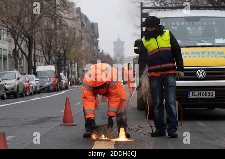 Berlino, Germania. 25 Nov 2020. I lavoratori rimuovono la segnaletica stradale temporanea sulla strada Unter den Linden. Dopo lo smantellamento del cantiere della nuova linea metropolitana U5, che va dal Rotes Rathaus alla porta di Brandeburgo, gli esperti stanno svolgendo i lavori di marcatura. Credit: Paul Zinken/dpa/Alamy Live News Foto Stock