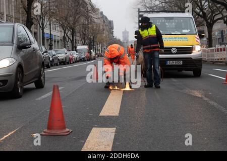 Berlino, Germania. 25 Nov 2020. I lavoratori rimuovono la segnaletica stradale temporanea sulla strada Unter den Linden. Dopo lo smantellamento del cantiere della nuova linea metropolitana U5, che va dal Rotes Rathaus alla porta di Brandeburgo, gli esperti stanno svolgendo i lavori di marcatura. Credit: Paul Zinken/dpa/Alamy Live News Foto Stock