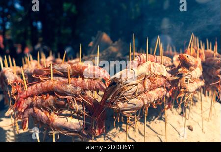 Spiedini di gamberi su carbone alla fiera Foto Stock