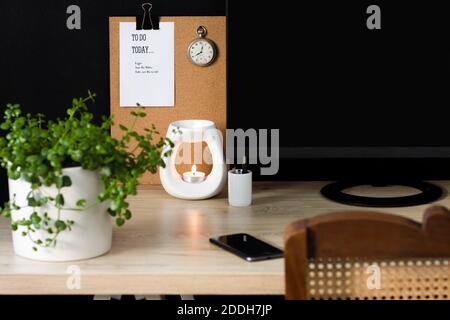 Una tranquilla scrivania da home Office con elementi decorativi naturali. Lo spazio è ordinato e favorisce la produttività in un ambiente calmante. Foto Stock