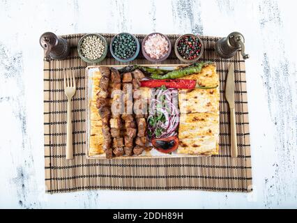 Cucina turca delizioso spiedino ciger. Spiedino di fegato, Turco Ciger Shish Kebab su piccolo barbecue con pomodori, delizioso, naturale, primo piano. Foto Stock
