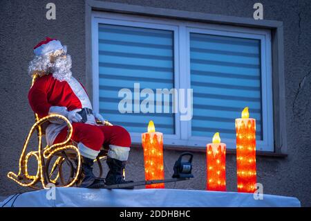 25 novembre 2020, Meclemburgo-Pomerania occidentale, Schönberg: Una figura illuminata di Babbo Natale si trova sul baldacchino di un edificio residenziale. Molti proprietari di abitazione attualmente decorano le loro proprietà con le luci di Natale. Foto: Jens Büttner/dpa-Zentralbild/dpa Foto Stock