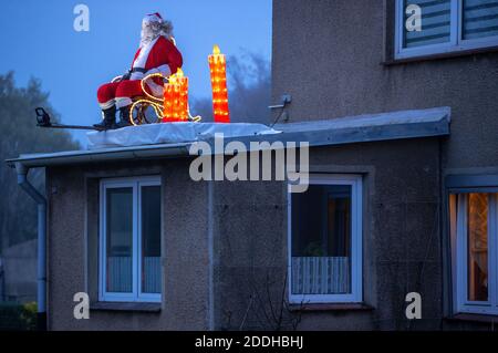 25 novembre 2020, Meclemburgo-Pomerania occidentale, Schönberg: Una figura illuminata di Babbo Natale si trova sul baldacchino di un edificio residenziale. Molti proprietari di abitazione attualmente decorano le loro proprietà con le luci di Natale. Foto: Jens Büttner/dpa-Zentralbild/dpa Foto Stock