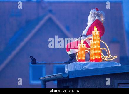 25 novembre 2020, Meclemburgo-Pomerania occidentale, Schönberg: Una figura illuminata di Babbo Natale si trova sul baldacchino di un edificio residenziale. Molti proprietari di abitazione attualmente decorano le loro proprietà con le luci di Natale. Foto: Jens Büttner/dpa-Zentralbild/dpa Foto Stock