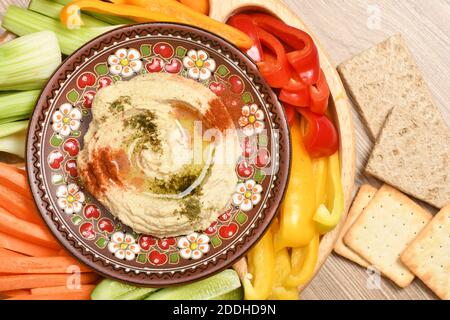 Un piatto di hummus con olio d'oliva, spezie e verdure. Foto ad alta risoluzione. Profondità di campo completa. Foto Stock