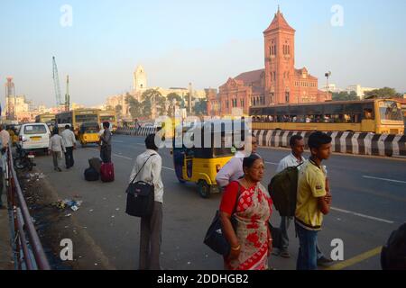 Chennai, Tamil Nadu, India - Marzo, 2014: Persone in attesa di autobus o tuk tuk taxi su una fermata di bas contro il Victoria Memorial Hall edificio Foto Stock