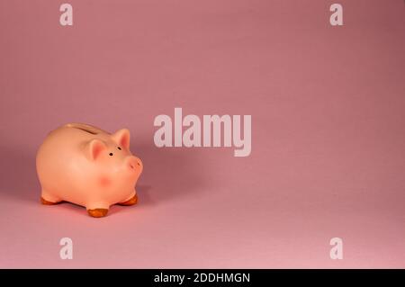 Rosa Piggy Bank lato contro sfondo rosa Foto Stock