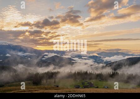 Splendido paesaggio montano. Incredibile tramonto sulle montagne sopra il villaggio. Paesaggio mozzafiato. Foto Stock