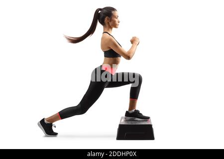 Foto di profilo a lunghezza intera di una giovane forma woma esercizio step aerobico isolato su sfondo bianco Foto Stock