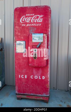 Distributori automatici antichi vintage Coca-Cola intatti con parti originali e. qualche patina in piedi verticale all'aperto contro un edificio Foto Stock