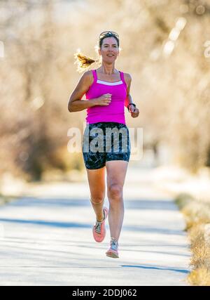 Attraente; di mezza età; fit donna che corre su sentiero lastricato; Salida; Colorado; USA Foto Stock