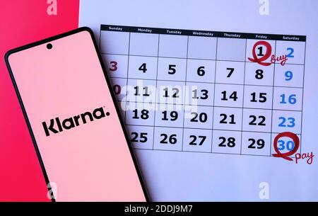 Schermata di accesso dell'app Klarna visualizzata sullo schermo dello smartphone posizionato sul calendario sfocato con date di acquisto etichettate Foto Stock