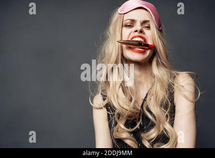 Donna ubriaca con rossetto in mano e maschera rosa sopra il suo volto Foto Stock