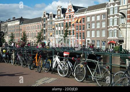 I pendolari percorrono i ponti e le passerelle lungo i canali di Amsterdam, Paesi Bassi Foto Stock