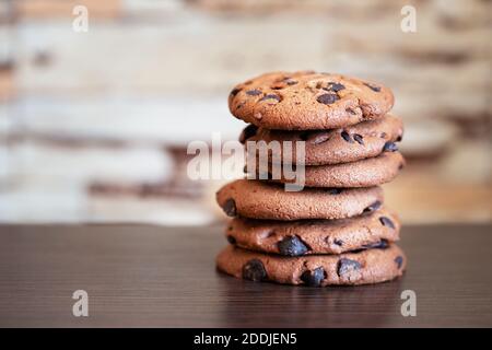 Pila di biscotti di farinata d'avena con cioccolato su tavolo di legno Foto Stock