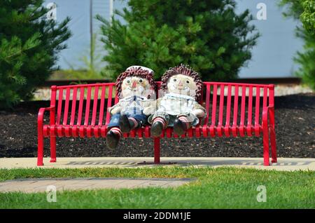 Arcola, Illinois, Stati Uniti. Le grandi bambole Raggedy Ann e Raggedy Andy adornano una panchina vicino al vecchio deposito ferroviario di Arcola, Illinois. Foto Stock
