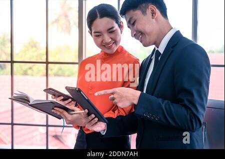 Lavoro di squadra di uomo d'affari e donna d'affari che parla sul posto di lavoro dell'ufficio. Concetto di cooperazione commerciale. Foto Stock