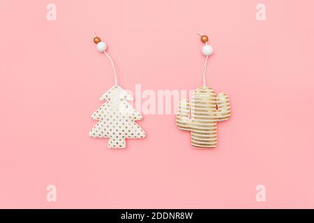 Albero di Natale e cactus in tessuto decorativo con motivo dorato su sfondo rosa con spazio di copia. Concetto di Natale o Capodanno. Stile piatto minimo Foto Stock