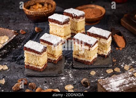 Mini pan di Spagna a strati fatto in casa con panna servita su ardesia Foto Stock