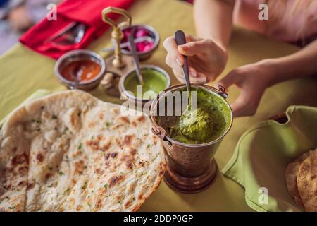 Donna caucasica mangiare cibo indiano nel caffè. Piatto tradizionale indiano. Cibo indiano. Primo piano Foto Stock