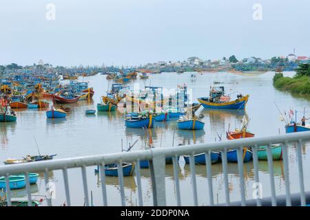 Al ponte che guarda le barche da pesca piene di fiume. Foto Stock