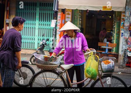 Una donna in bicicletta che vende alimenti. Foto Stock