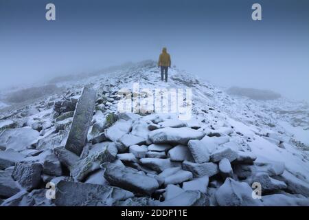 Un solitario vagabondatore in un paesaggio innevato. Solitudine, montagne, inverno, nebbia, neve. Foto Stock