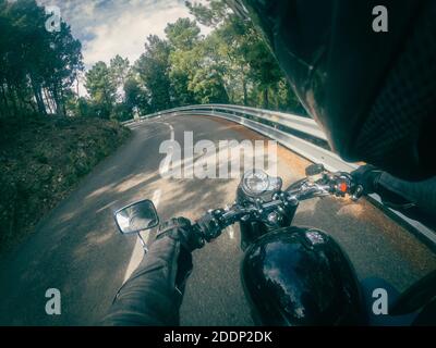 Guida di un vecchio retro nero motociclista punto di vista su una strada tortuosa Foto Stock