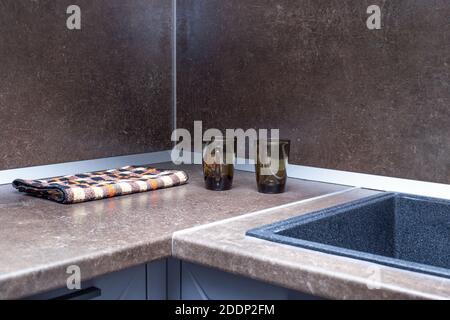 il piano cucina e il grembiule sono marroni con un lavello di pietra nero. Interno della camera. Foto Stock