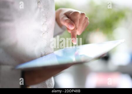 Il dito femminile punta allo schermo del tablet incluso Foto Stock