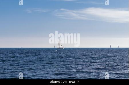 Barca a vela nel Mar Mediterraneo con un cielo blu sullo sfondo Foto Stock