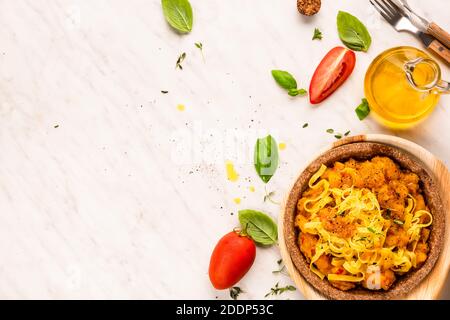 Pasta italiana fatta in casa con salsa vegetariana servita in bocce a base di piante commestibili. Cucina ecologica. Foto Stock