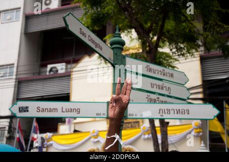 Bangkok, Thailandia. 16 agosto 2020. Un protestore che fa il saluto a tre dita accanto ai cartelli stradali durante una dimostrazione al Monumento alla democrazia. Il saluto a tre dita è un simbolo di proteste anti-governative in Thailandia che significa libertà, libertà e fraternità ispirate ai film dei Giochi della fame. Credit: SOPA Images Limited/Alamy Live News Foto Stock